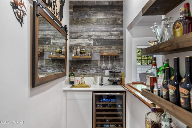 bar with wine cooler, indoor wet bar, and a sink