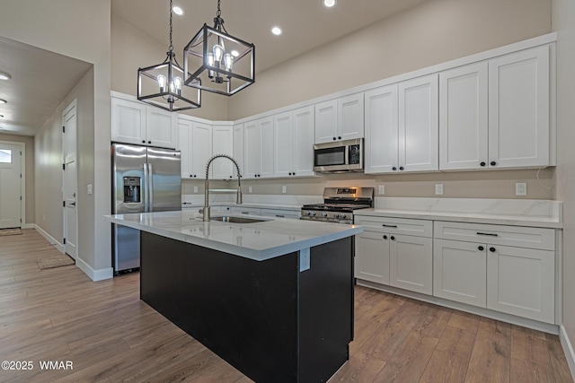 860 E Blue Jay Ln, Show Low, AZ 85901 - kitchen featuring stainless steel appliances, a chandelier, a high ceiling, light wood finished floors, and decorative light fixtures