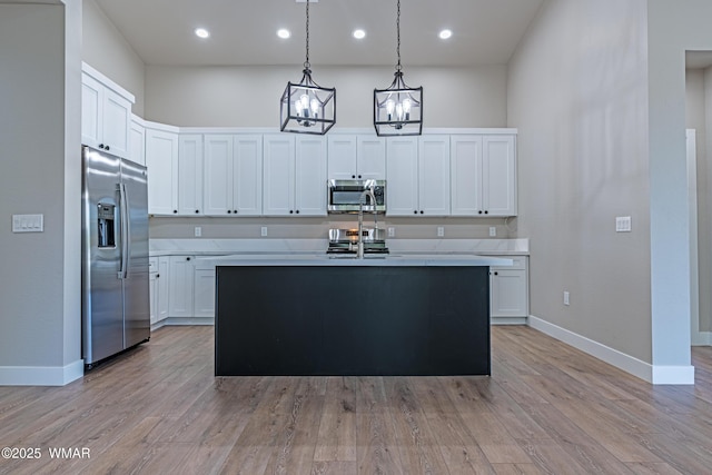 860 E Blue Jay Ln, Show Low, AZ 85901 - kitchen with stainless steel appliances, light countertops, pendant lighting, white cabinetry, and recessed lighting