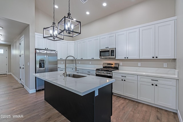 860 E Blue Jay Ln, Show Low, AZ 85901 - kitchen with appliances with stainless steel finishes, a towering ceiling, a chandelier, wood finished floors, and decorative light fixtures