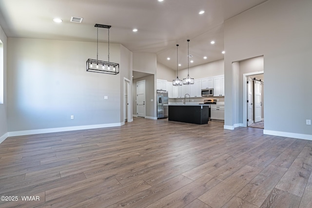 860 E Blue Jay Ln, Show Low, AZ 85901 - unfurnished living room with high vaulted ceiling, light wood-style flooring, and recessed lighting