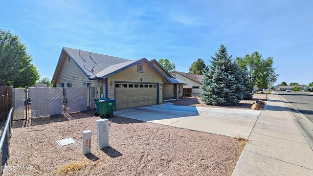 860 N Kiaya Ln, Show Low, AZ 85901 - view of side of home featuring driveway, a gate, and a garage