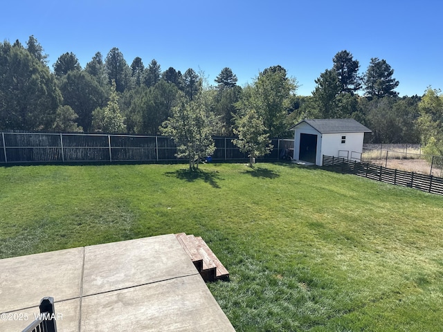 view of yard with a fenced backyard and an outbuilding