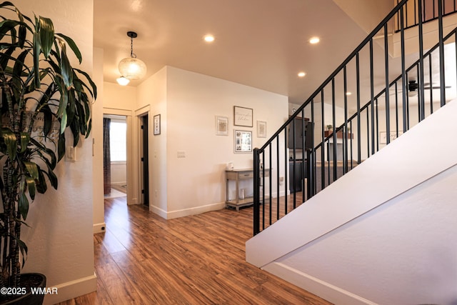 foyer featuring baseboards, stairway, wood finished floors, and recessed lighting