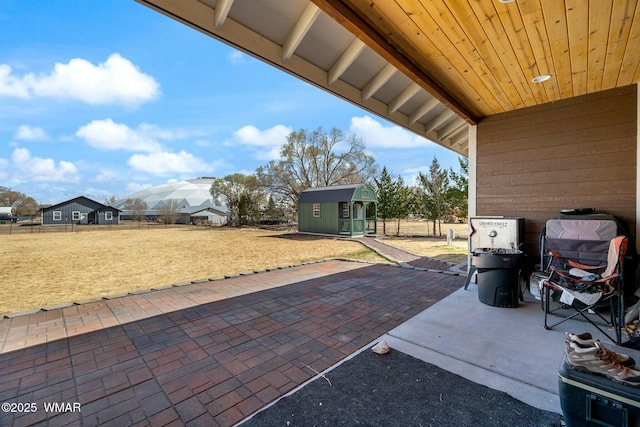 view of patio with an outbuilding and fence