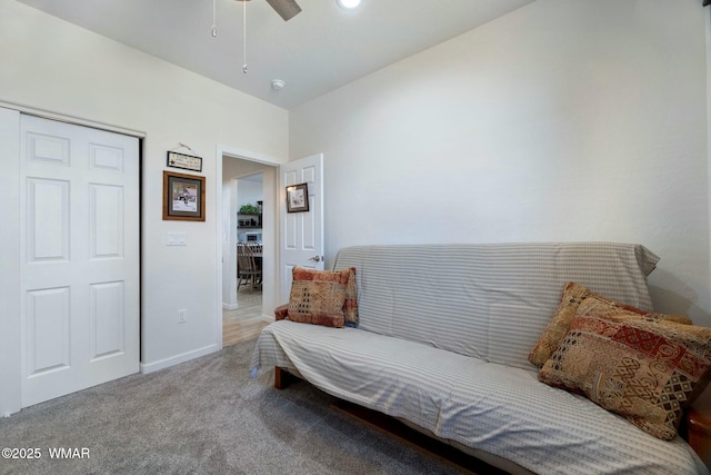 living area with carpet, baseboards, and ceiling fan