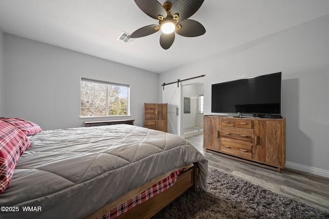 6668 Bandido Way, Show Low, AZ 85901 - bedroom with a barn door, light wood finished floors, ensuite bath, baseboards, and visible vents