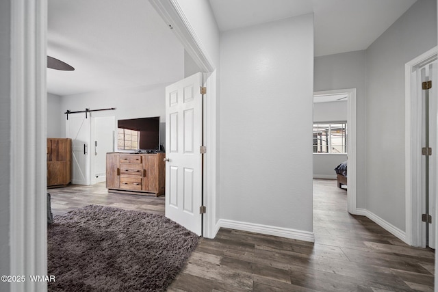 6668 Bandido Way, Show Low, AZ 85901 - hallway with dark wood-type flooring, a barn door, and baseboards
