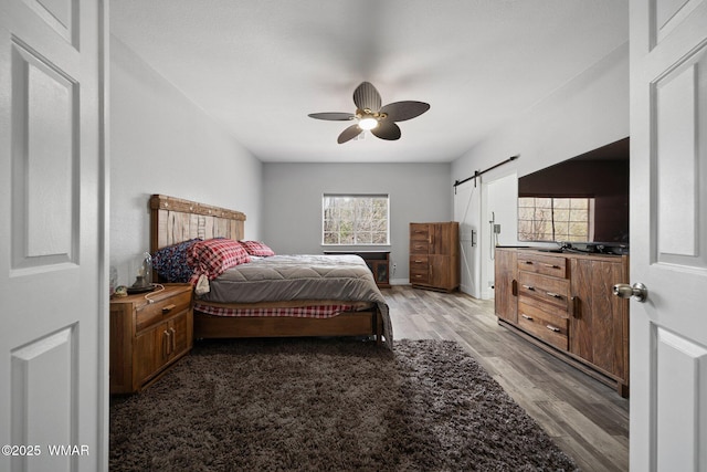 6668 Bandido Way, Show Low, AZ 85901 - bedroom with baseboards, ceiling fan, light wood-type flooring, and a barn door