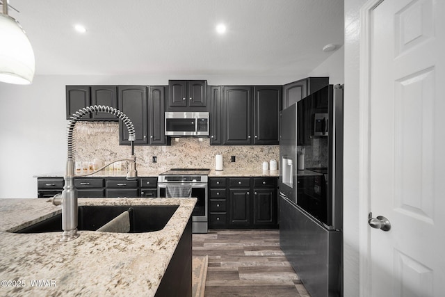 6668 Bandido Way, Show Low, AZ 85901 - kitchen featuring wood finished floors, light stone countertops, a sink, appliances with stainless steel finishes, and backsplash