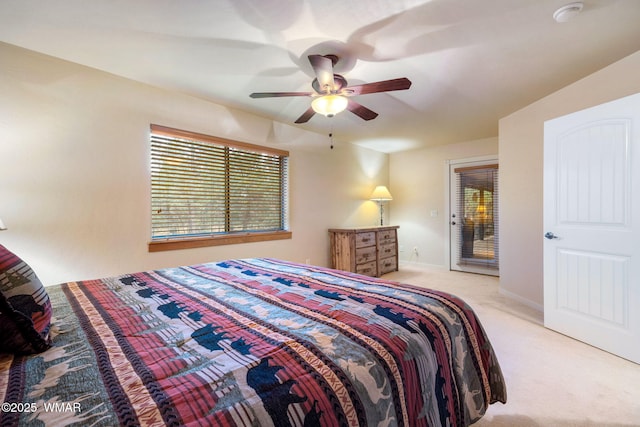 bedroom featuring light carpet, ceiling fan, multiple windows, and baseboards