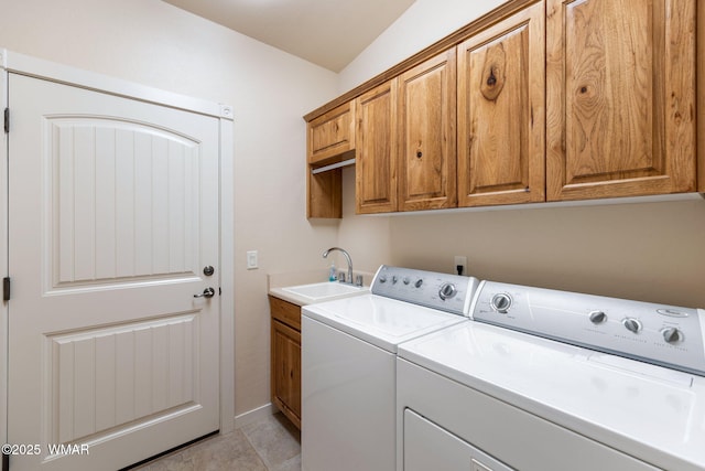 clothes washing area featuring washing machine and clothes dryer, light tile patterned floors, cabinet space, a sink, and baseboards