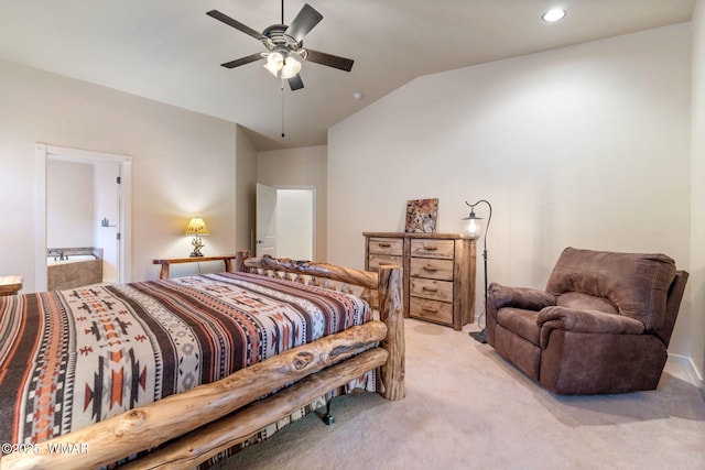 bedroom featuring lofted ceiling, ensuite bath, a ceiling fan, and light colored carpet