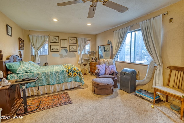 bedroom with carpet, multiple windows, ceiling fan, and a textured ceiling