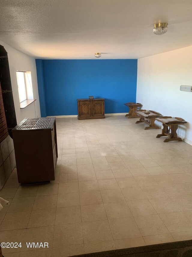 interior space featuring a textured ceiling and baseboards