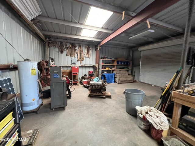 garage featuring metal wall, gas water heater, and a workshop area