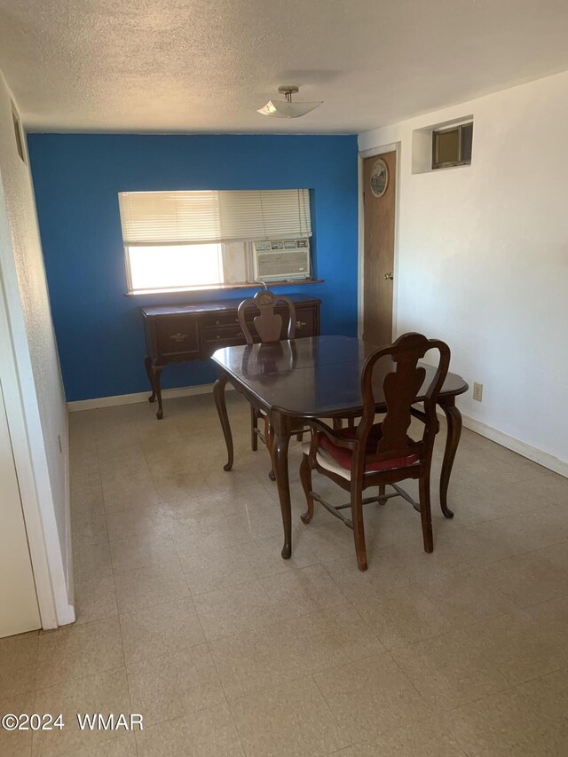 dining space featuring a textured ceiling, baseboards, cooling unit, and tile patterned floors