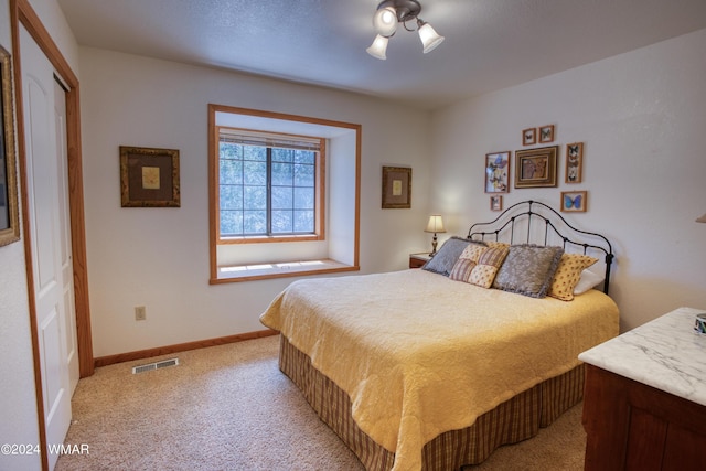 bedroom with baseboards, visible vents, and light colored carpet