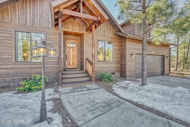 view of exterior entry featuring a garage, crawl space, and driveway