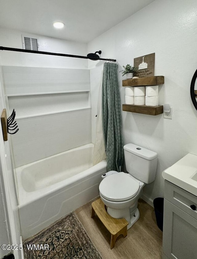 bathroom with visible vents, toilet, wood finished floors, shower / tub combo with curtain, and vanity