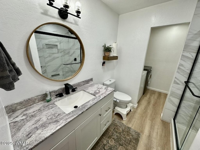 bathroom featuring toilet, a shower stall, vanity, and wood finished floors