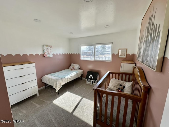 bedroom featuring baseboards and dark carpet