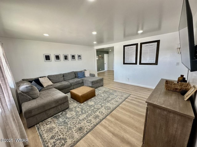 living room featuring baseboards, light wood-style flooring, and recessed lighting