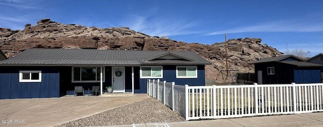 view of front of home featuring a fenced front yard, metal roof, and board and batten siding