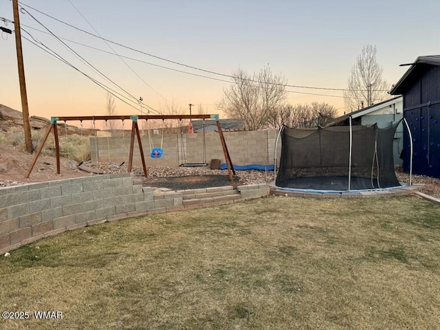 view of yard featuring a trampoline, a fenced backyard, and a playground