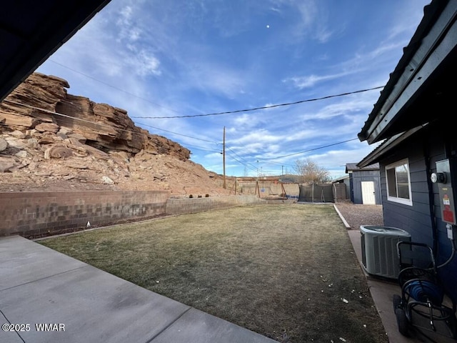 view of yard with central air condition unit, a fenced backyard, and a trampoline