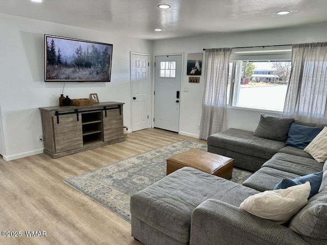 living area with light wood-style flooring, baseboards, and recessed lighting