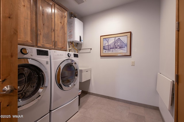 laundry room with baseboards, washer and clothes dryer, light floors, tankless water heater, and cabinet space