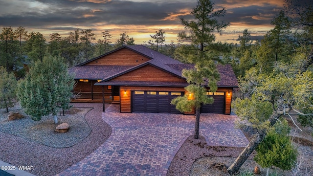 rustic home featuring decorative driveway and a garage