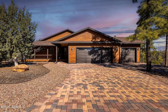 ranch-style house featuring decorative driveway and an attached garage