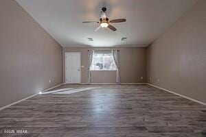 interior space with dark wood-style floors, ceiling fan, and baseboards