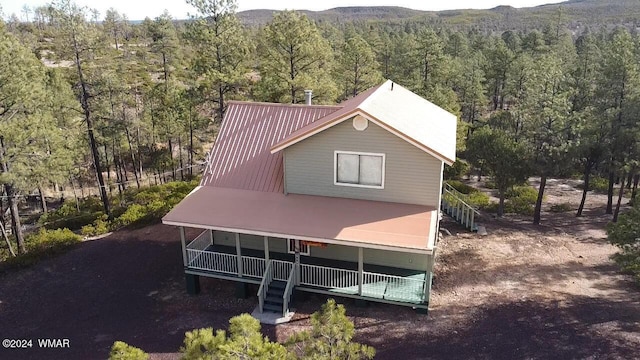 exterior space with a forest view, a mountain view, and metal roof