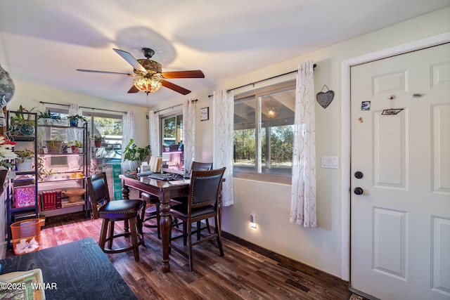 dining room featuring baseboards, dark wood finished floors, and a ceiling fan