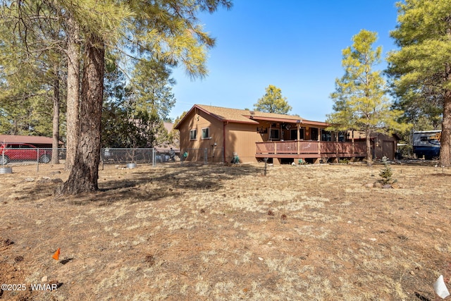 rear view of property with a deck and fence