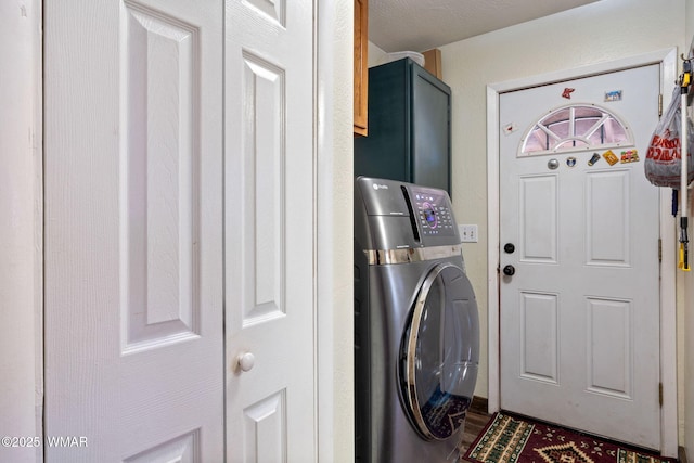 clothes washing area featuring washer / clothes dryer and cabinet space