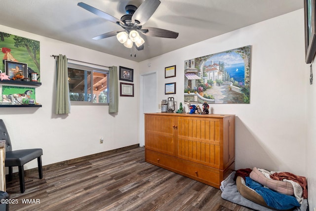 sitting room with dark wood-style floors and a ceiling fan