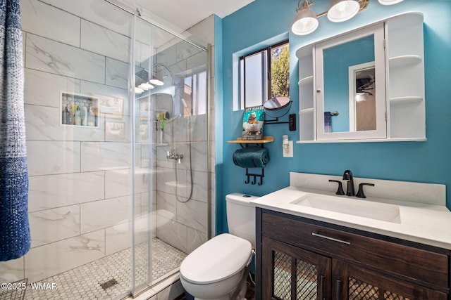 bathroom with a stall shower, vanity, and toilet