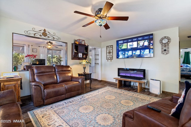 living area featuring dark wood-style floors, ceiling fan, and baseboards