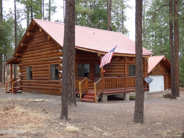 30 County Road 2066, Alpine, AZ 85920 - view of front of home featuring metal roof, log siding, a garage, and a porch