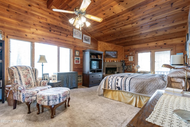 bedroom featuring wooden walls, carpet, high vaulted ceiling, a fireplace, and wooden ceiling