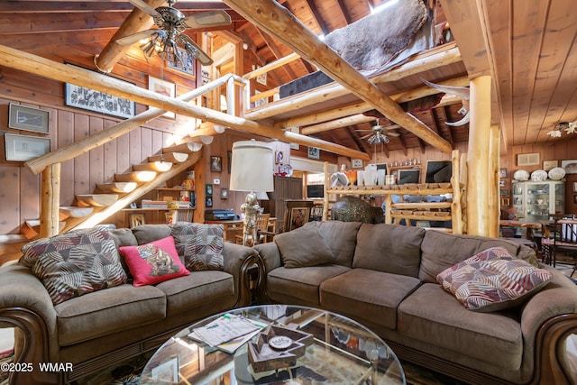 living area with wooden walls, stairway, and ceiling fan