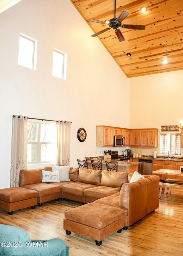 living area featuring wooden ceiling, light wood-style flooring, high vaulted ceiling, and ceiling fan