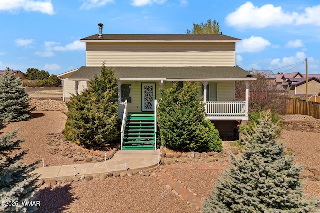 view of front of property with fence, covered porch, and stairs