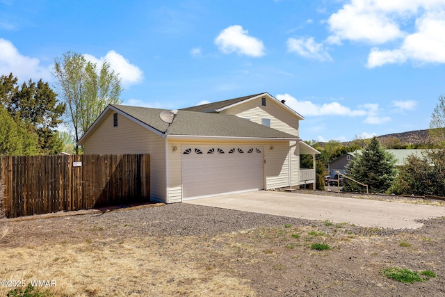 view of front facade featuring fence, driveway, and a garage