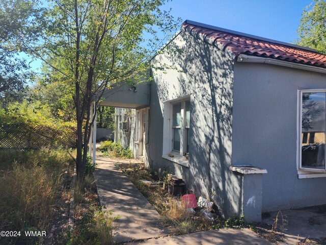 view of home's exterior with stucco siding and a tiled roof