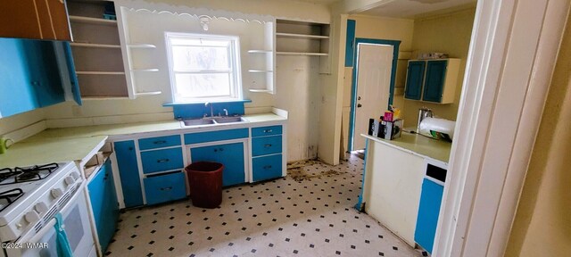 kitchen with light floors, white gas range, light countertops, and a sink